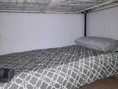 a bed in a room with a white wall at Sweet house close to airport in El Prat de Llobregat