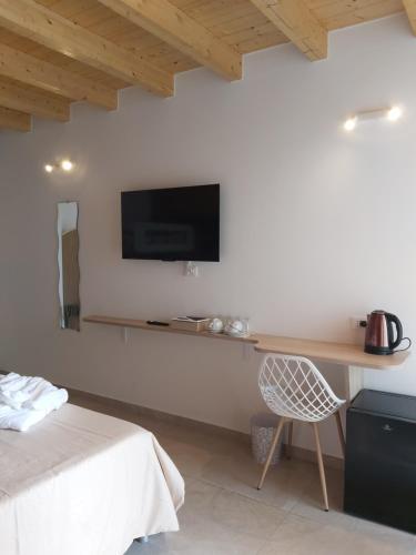 a bedroom with a desk and a tv on the wall at Cascina Olmetto di Sotto in Ghedi
