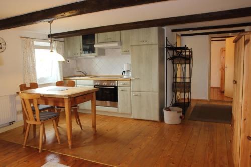a kitchen with a wooden table and a wooden floor at Ferienwohnung Hochwaldblick in Hörnitz