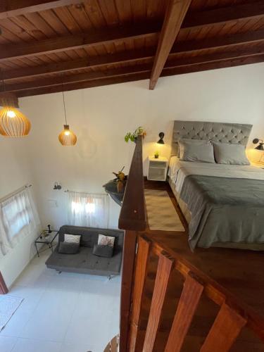 a bedroom with a large bed and a couch at Chale aconchegante da ilha in Florianópolis