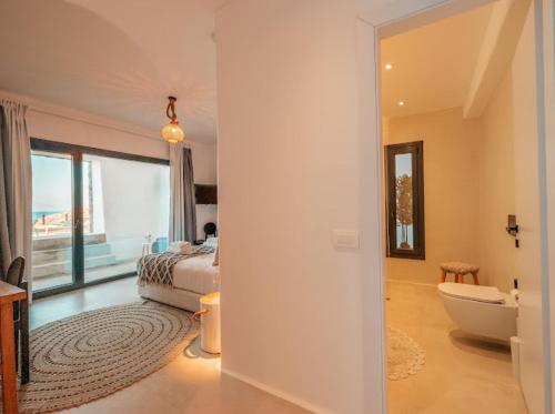 a bedroom with a bed and a bathroom with a tub at Shark Luxury Villa in Agios Ioannis Mykonos