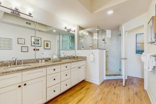 un bagno con due lavandini e una doccia di Dolphin's Cove - Clearwater Beach, FL a Clearwater Beach