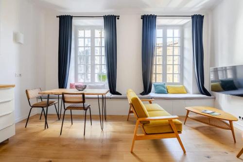 une salle à manger avec une table, des chaises et des fenêtres dans l'établissement Chemin du muguet T2 hyper centre, à Bordeaux