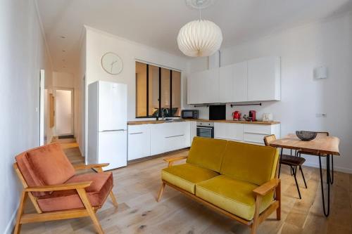 un salon avec un canapé et une table et une cuisine dans l'établissement Chemin du muguet T2 hyper centre, à Bordeaux