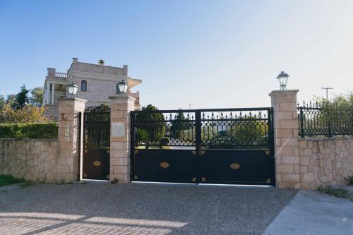 a gate to a house with a building behind it at Seaside "Stone & Light Villa II" close to Aegina City in Khlóï