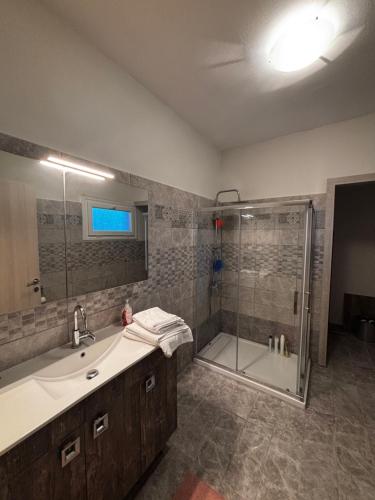 a bathroom with a shower and a sink and a tub at Mediterraneo Suites with Pool & Sea View Escape in Nea Kalikratia