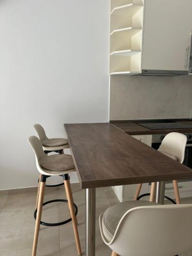 a wooden table with four chairs and a kitchen at Heavenly hills in Radanovići