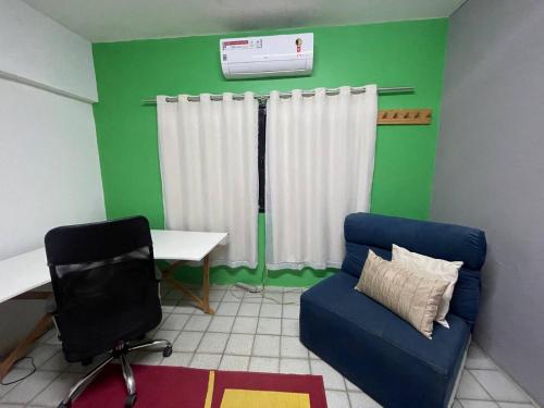 a living room with a blue couch and a desk at Urban Suite Comfort in Garanhuns