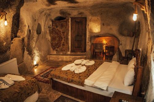a bedroom with two beds in a cave at Cappadocia Snora Cave in Nevsehir
