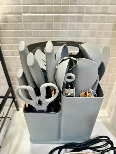 a container filled with utensils on a table at Rattanasup House in Hat Yai