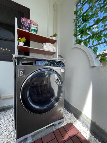 a washing machine sitting next to a wall at Rattanasup House in Hat Yai