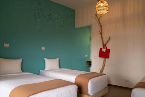 two beds in a room with a blue wall at Hotel con Corazon Monteverde in Monteverde Costa Rica