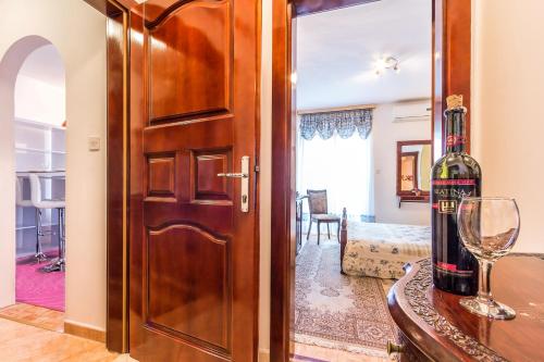 a wooden door with a bottle of wine on a table at Villa Roses Apartments & Wellness in Ičići