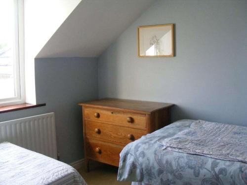 a bedroom with a bed and a dresser and a window at Dolphinwatch House Comfortable holiday residence in Renvyle