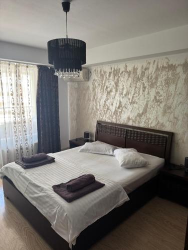 a bedroom with a bed with two towels on it at VIRGO Apartaments Mamaia in Mamaia