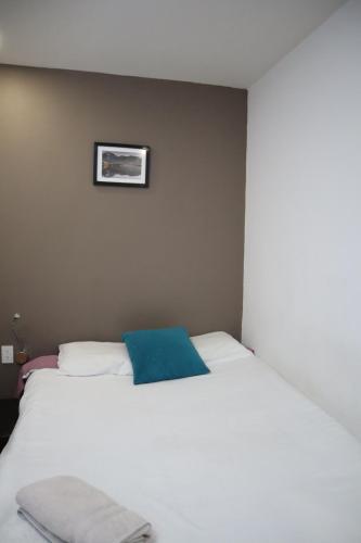 a bedroom with a white bed with a blue pillow at Habitación privada con TV Polanco Hab 4 in Mexico City