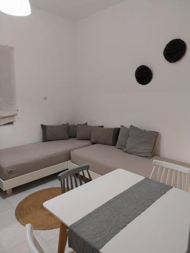 a living room with a couch and a table at Galini Rooms & Apartments in Finikas