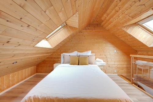 ein Schlafzimmer mit einem Bett im hölzernen Dachgeschoss in der Unterkunft Le Nid Tourangeau in Tours
