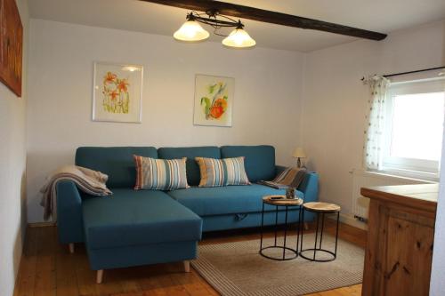 a living room with a blue couch and a table at Ferienwohnung Koitscheblick in Hörnitz