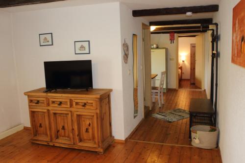 a living room with a television on a wooden cabinet at Ferienwohnung Koitscheblick in Hörnitz