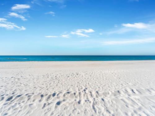 a sandy beach with the ocean in the background at Grand Panama Resort - Ocean Views, Heated Pool & Tub 3 BR 3 Full BA Sleeps 10 in Panama City Beach