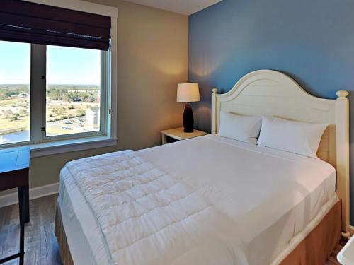 a bedroom with a large white bed and a window at Grand Panama Resort - Ocean Views, Heated Pool & Tub 3 BR 3 Full BA Sleeps 10 in Panama City Beach