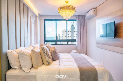 a bedroom with a large bed with a window at Flats Confortáveis em Manaíra Mindset - Qavi in Tambaú