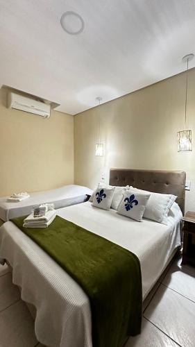 a hotel room with two beds with green sheets at Magnus Pousada in Paraty