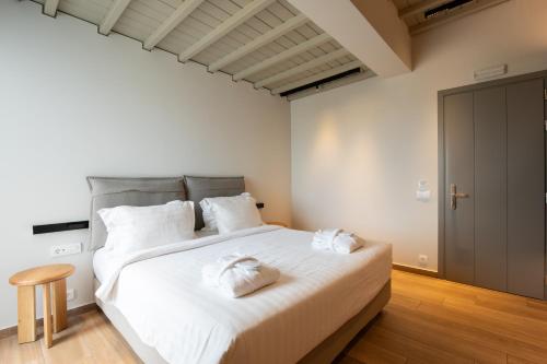 a bedroom with a large white bed with white pillows at Fabrikas in Mýkonos City