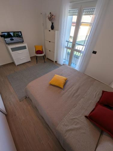 a bedroom with a large bed with a yellow pillow on it at Apartment Eleven - 4 guests in Novara