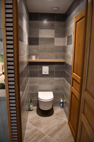 une salle de bain avec toilettes dans une pièce carrelée dans l'établissement Le Bikini, à Fort-Mahon-Plage