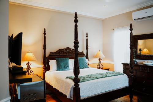 a bedroom with a bed and a dresser and a television at Shangri-La Boutique Bed & Breakfast in West Bay