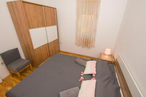 a small room with a bed and a chair at Apartments More in Kožino