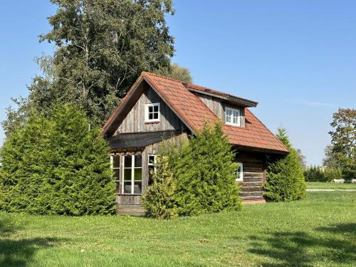 a small house with two trees in front of it at Cozy River House with hot tub in Pärnu