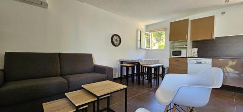 a living room with a couch and a kitchen at T3 Dolce & Vita D5 avec Piscine et vue Montagnes in Propriano