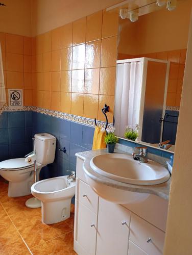 a bathroom with two sinks and a toilet and a mirror at La casa de Don Juan in Puntallana