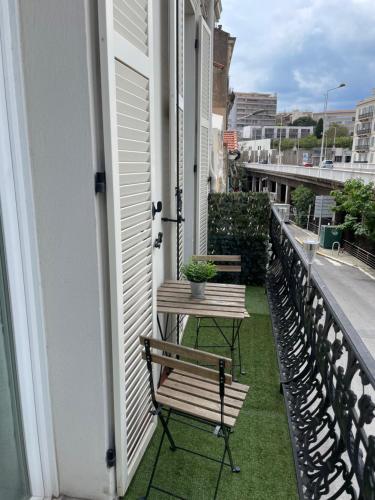 une terrasse couverte avec deux bancs et une table sur un balcon dans l'établissement Cannes - Forville- 6 personnes, à Cannes