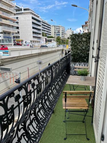 - un balcon avec une table et un banc dans un bâtiment dans l'établissement Cannes - Forville- 6 personnes, à Cannes