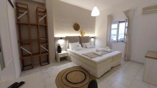 a bedroom with a large white bed and a window at Galini Rooms & Apartments in Finikas