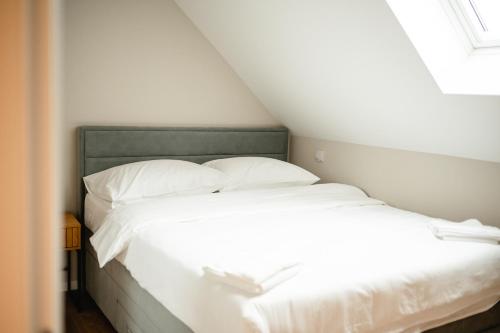 Una cama con sábanas blancas y almohadas en una habitación. en Kaptol 4, en Zagreb