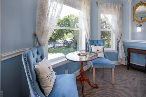 a blue room with a table and two chairs and a window at The Irish Inn in Hood River