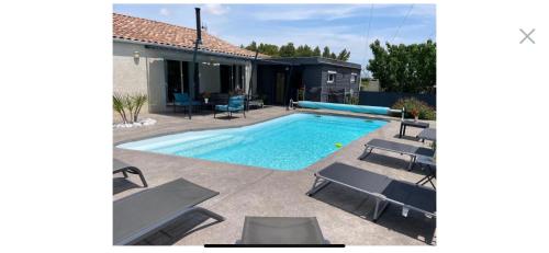une piscine avec des chaises et une maison dans l'établissement petit paradis au soleil, à Narbonne