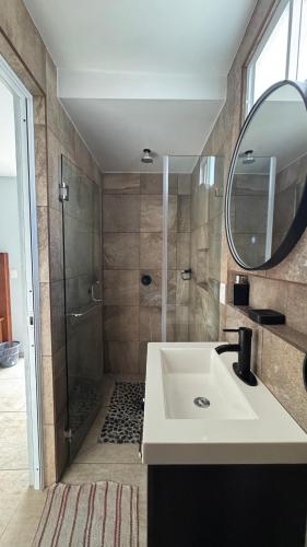 a bathroom with a sink and a shower with a mirror at Cuarto a unos pasos de foro sol GNP y AICM in Mexico City