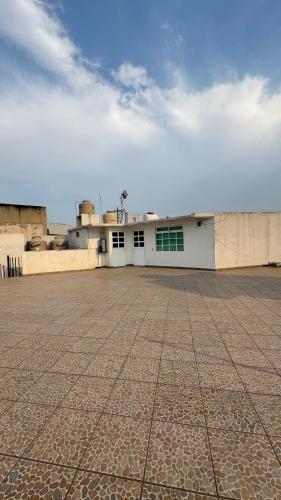 a building with white doors and a tile floor at Cuarto a unos pasos de foro sol GNP y AICM in Mexico City