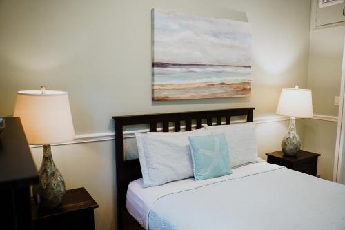 a bedroom with a bed with two lamps and a painting at Shangri-La Boutique Bed & Breakfast in West Bay