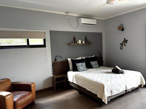 a bedroom with a bed and a chair at Casa Mantana Bonaire in Kralendijk