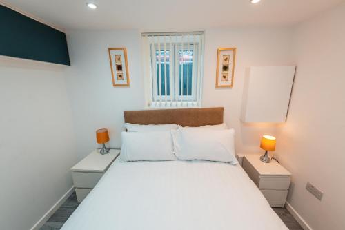 セールにあるSale 2-Bedroom Apt - Sleeps 5 - Free Parkingのベッドルーム(白いベッド1台、ランプ2つ付)