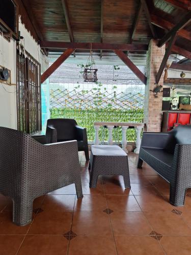 a patio with chairs and a table and a window at Villa en Orotina con Piscina in Coyolar