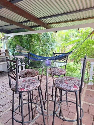 a glass table and four chairs on a patio at Villa en Orotina con Piscina in Coyolar