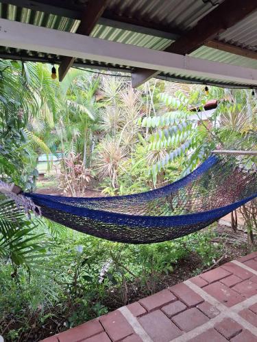 a hammock hanging from a roof in a garden at Villa en Orotina con Piscina in Coyolar